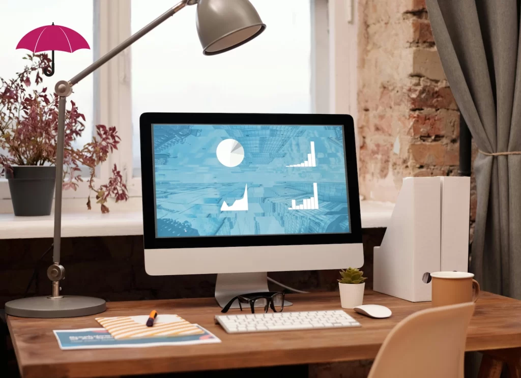 A neatly decorated desk with a computer showing charts and graphs on the screen during a website audit